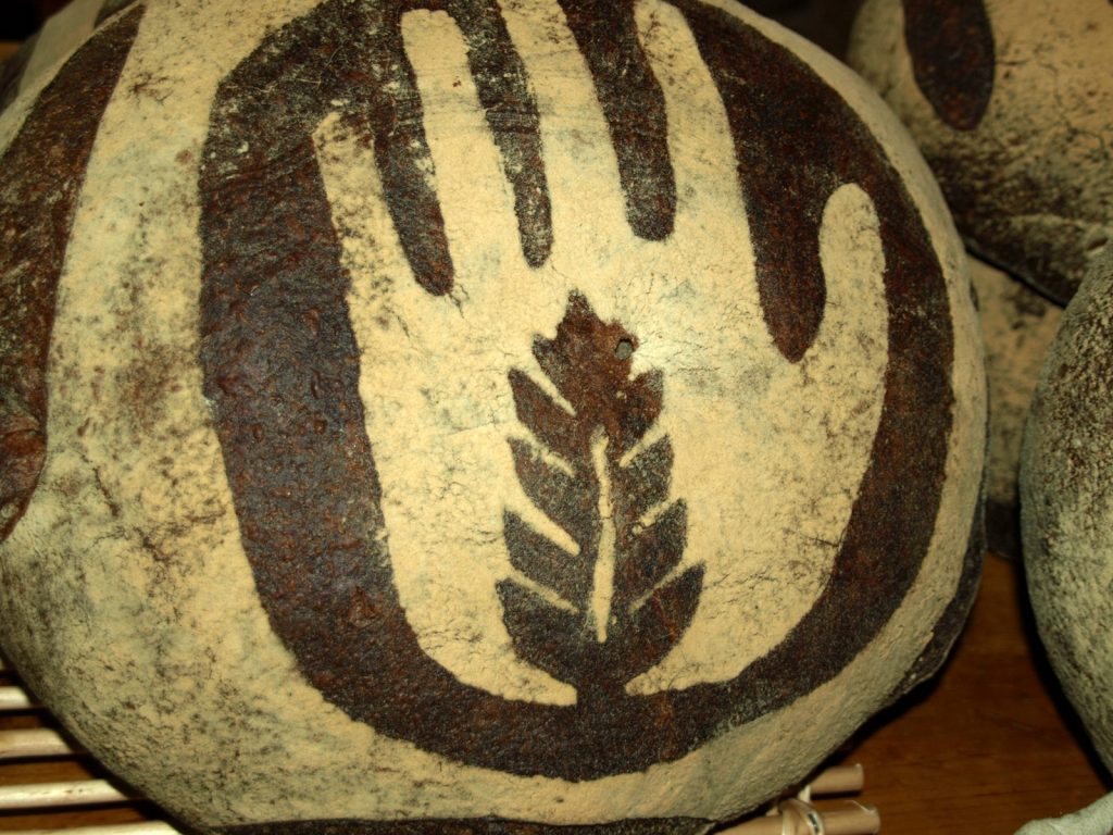 A loaf of bread sporting a design of a hand and a leaf